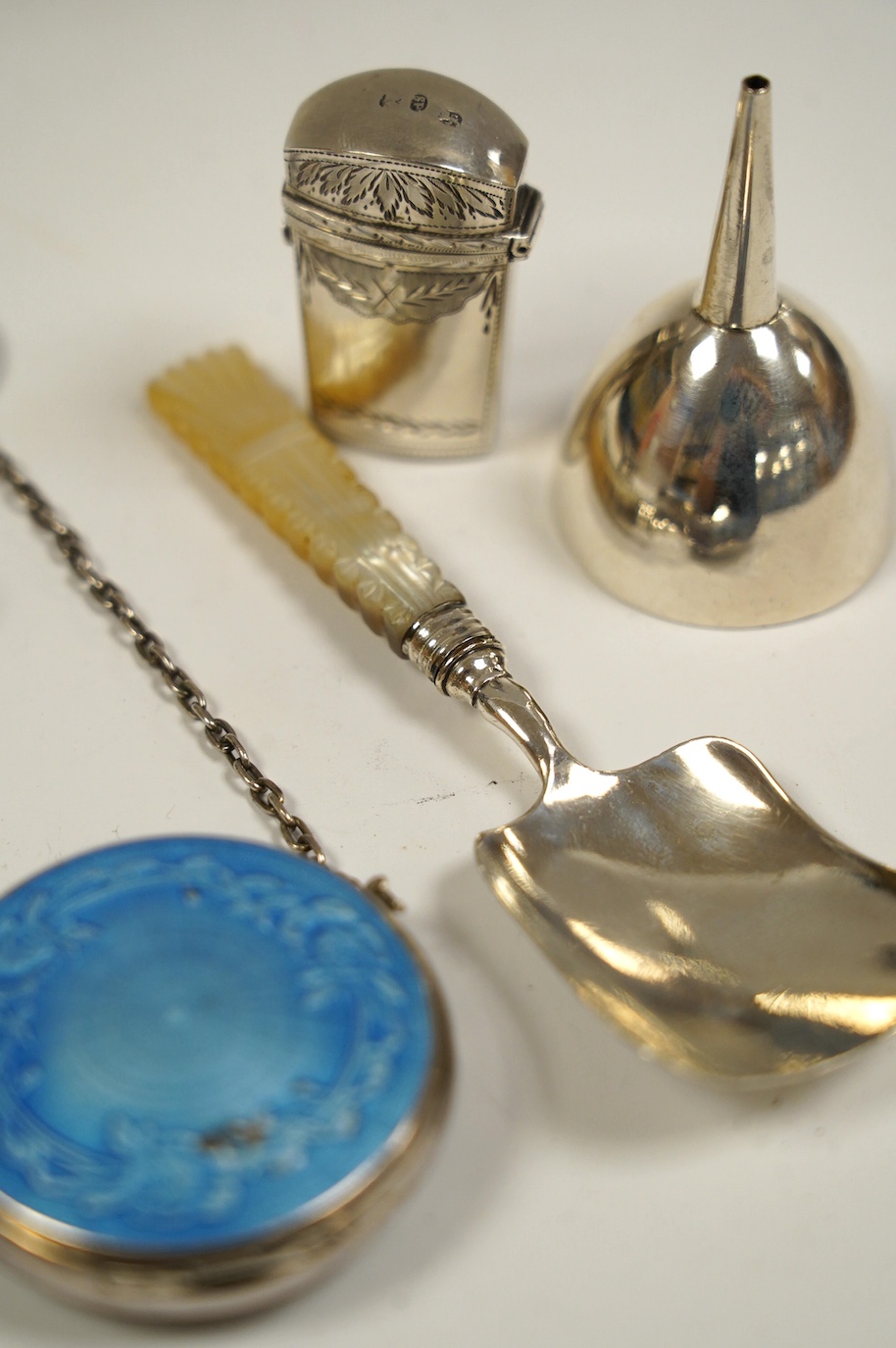 Five assorted small silver items including an early 19th century silver scent bottle case by Samuel Pemberton, containing a small glass flask, a mother of pearl handled caddy spoon, a silver whistle, a small funnel and a